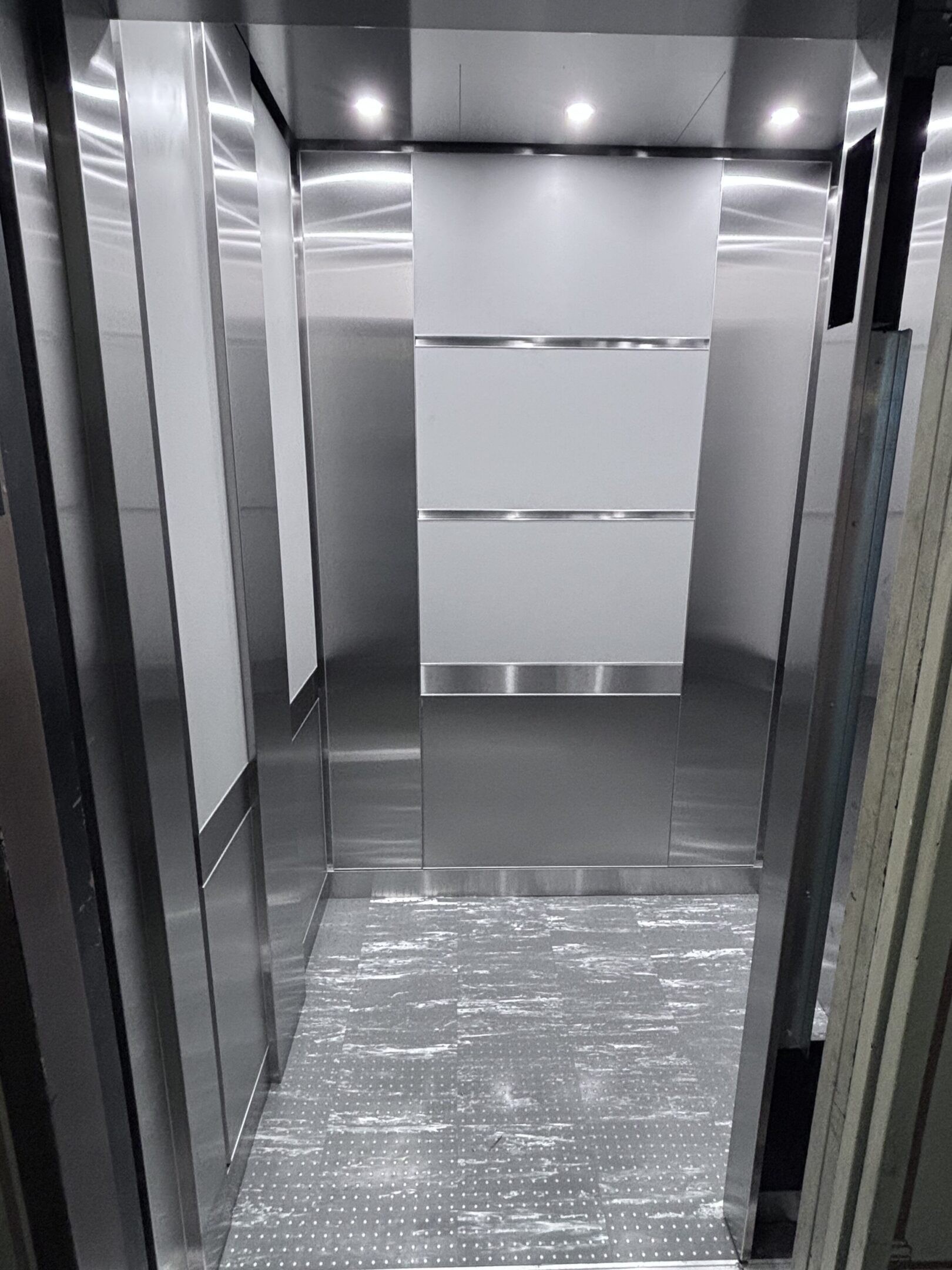 Elevator cab interior featuring dove grey panels & trim by NYC Elevator Cab Co.